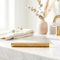 Gold-colored product on a marble surface with a blurred background